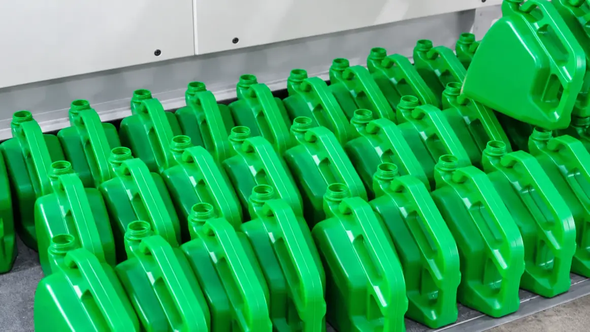 Rows of finished green plastic jerrycans coming off a production line